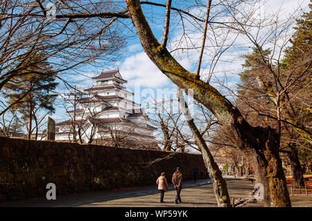 DEC 4, 2018 Aizu Wakamatsu, Japan - Aizu Wakamatsu Tsuruga Schloss und touristische Spaziergang entlang der Steinmauer unter großen Bäumen im Winter. Fukushima Samurai Herr Stockfoto