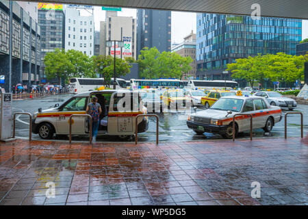 Fukuoka, Japan - 13. Juli 2019 - der Taxistand, Fahrgäste vor einem Bahnhof Gebäude in Fukuoka, Japan, am 13. Juli 2019 Stockfoto