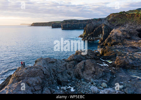 Zwei Fotografen die Bilder von den Sonnenaufgang an der felsigen Küste von Ponta do Mistério auf Terceira Insel der Azoren. Am Morgen Licht hits Gi Stockfoto