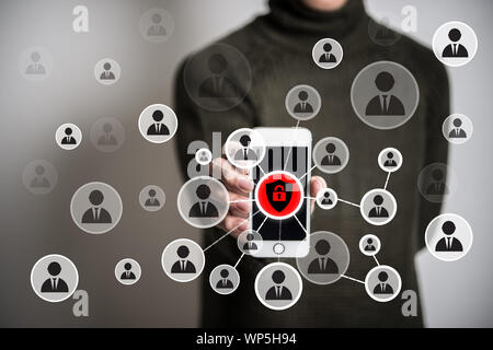Junger Mann mit modernen Smartphone mit Menschen Sicherheit Symbole auf dem Bildschirm Hintergrund. Stockfoto