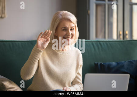 Lächelnd reife Frau sprechen auf Video Anruf auf Laptop Stockfoto