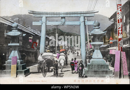 [1900s Japan - TITEL] - Steinlaternen und einem erschrockenen torii Tor am Eingang weg zu Ikuta Jinja, ein Shinto Schrein in Kobe, Hyogo Präfektur. Viele Läden säumen die Straße. Der Schrein ist einer der ältesten Schreine in Japan und ist in der Nihon Shoki, die zweite älteste Buch der klassischen japanischen Geschichte erwähnt. Der Schlacht von Ichi no Tani (1184) fand in und um ikuta Schrein. 20. jahrhundert alte Ansichtskarte. Stockfoto