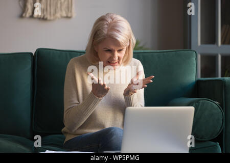 Frustriert, reife Frau mad Probleme auf Laptop erhalten Stockfoto