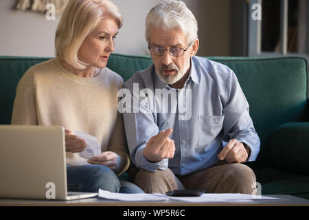 Ältere Mann und Frau berechnen Finanzen Rechnungen bezahlen online Stockfoto