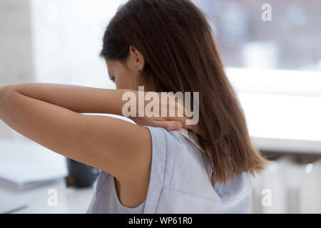 Müde junge Frau Rücken- Schmerzen leiden. Stockfoto