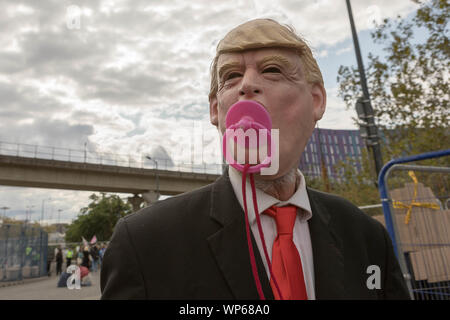 London, Großbritannien. September 2019. Ein Aktivist, der eine Donald Trump Maske trägt und eine pinkfarbene Puppe im Mund hält, nimmt an der Stop the Arms Fair Protest vor dem Excel Centre in London Teil. Die Demonstration, die Teil des von Campaign Against Arms Trade (CAAT) koordinierten „Festival of Resistance“ war, widersetzte sich der im September 2019 abgehaltenen Waffenmesse „Defence & Security Equipment International“ (DSEI). Penelope Barritt/Alamy Live News Stockfoto