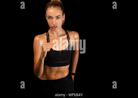 Sportliche Mädchen Jogging auf Schwarz Studio Hintergrund Stockfoto
