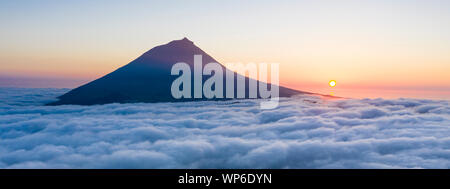 Luftbild mit magischen Sonnenuntergang über eine niedrige Wolkendecke über der Insel Pico, mit Ponta do Pico (Pico), der höchste Berg von Portugal Stockfoto