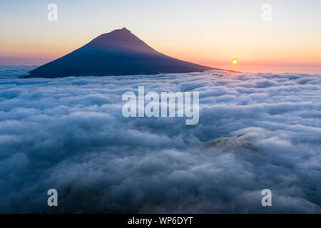 Luftbild mit magischen Sonnenuntergang über eine niedrige Wolkendecke über der Insel Pico, mit Ponta do Pico (Pico), der höchste Berg von Portugal Stockfoto