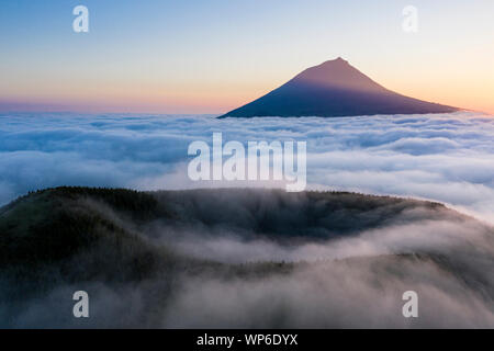 Luftbild mit magischen Sonnenuntergang über eine niedrige Wolkendecke über der Insel Pico, mit Ponta do Pico (Pico), der höchste Berg von Portugal Stockfoto