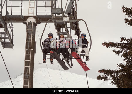 VEYSONNAZ, Schweiz - Februar 03, 2010: Unbekannter Skifahrer und Snowboarder auf eine 4-er Sesselbahn Stockfoto