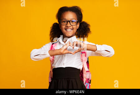 Afrikanische amerikanische Schülerin zeigen Herz Geste mit den Händen im Studio Stockfoto