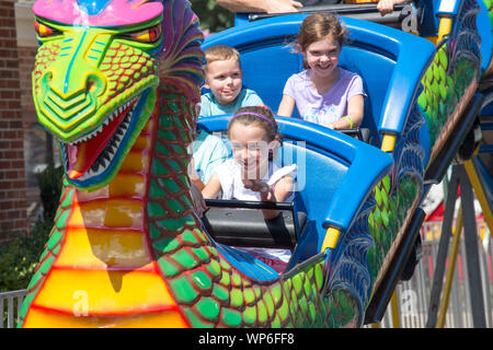 MATTHEWS, NC (USA) - 31. August 2019: Nahaufnahme der Kinder genießen eine Achterbahnfahrt bei der jährlichen 'Matthews Lebendig" Gemeinschaft Festival. Stockfoto