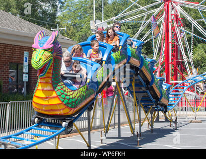 MATTHEWS, NC (USA) - 31. August 2019: Eltern und Kinder eine Achterbahnfahrt bei der jährlichen 'Matthews Lebendig" Gemeinschaft Festival genießen. Stockfoto