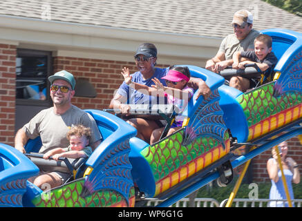 MATTHEWS, NC (USA) - 31. August 2019: Eltern und Kinder eine Achterbahnfahrt bei der jährlichen 'Matthews Lebendig" Gemeinschaft Festival genießen. Stockfoto