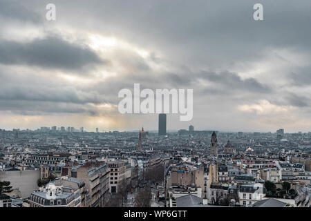 Paris, Frankreich, 28. Januar 2018: hohe stadtbild Blick auf dem Tour Montparnasse und dem dunklen bewölkten Himmel mit Licht Piercing durch. Stockfoto