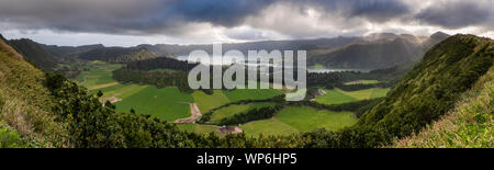 Landschaft Panorama mit Sonnenlicht Strahlen durch die Wolken über den beeindruckenden vulkanischen Krater Sete Cidades, Insel Sao Miguel, Azoren glänzen. Uhr Stockfoto