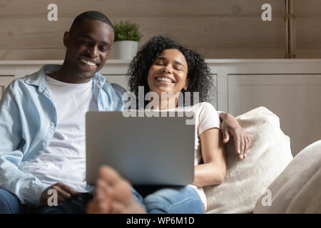 Happy biracial Paar mit Laptop zu Hause lachen Entspannen Stockfoto