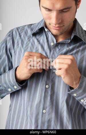 Mann Zuzuknöpfen vor Kleid Shirt. Kleidung Arten für Männer anziehen. Stockfoto