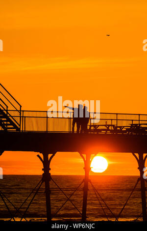 Aberystwyth Wales UK, Samstag, 07. September 2019 UK Wetter: die Menschen sind von der schönen Anfang Herbst Sonnenuntergang über Pier Aberystwyth, Wales UK silhouetted, am Ende eines Tages des klaren Himmel und warmen Sonnenschein, ein kalter Nordwind Brise gemildert. Foto Keith Morris/Alamy leben Nachrichten Stockfoto