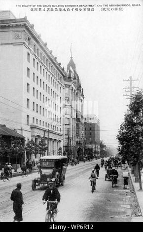 [1920s Japan - sakaisuji Einkaufsstraße in Osaka] - Shirokiya Kaufhaus Sakaisuji in Osaka. Tokioter Shirokiya seinen ersten Store in Osaka in Shinsaibashi eröffnet 2-chome 1903 (Meiji 36). 1921 (taisho 10), es ist ein 9-stöckiges Gebäude auf Sakaisuji, die einen wichtigen Straßenbahnlinie hatte. Als Ergebnis Sakaisuji nicht weniger als vier große Kaufhäuser untergebracht und wurde der wichtigsten Einkaufsstraße in Osaka. 20. jahrhundert alte Ansichtskarte. Stockfoto