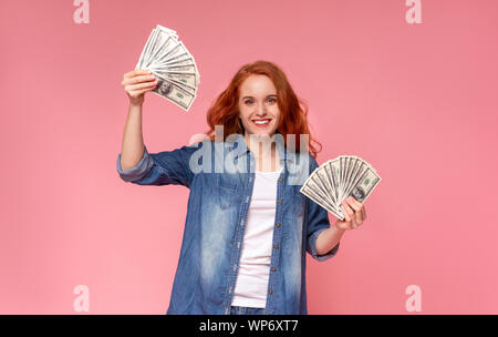 Fröhliche tausendjährigen Mädchen mit roten Haaren und viel Geld Stockfoto