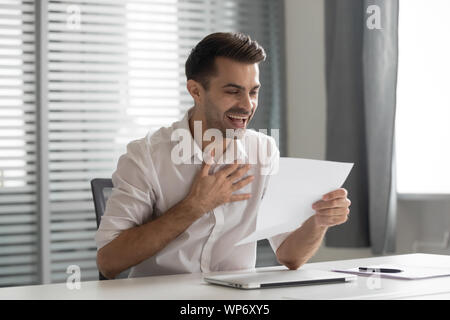 Begeistert junge Unternehmer Brief mit unerwartet gute Nachrichten empfangen. Stockfoto