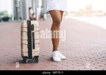 Junge schwarze Frau mit Koffer warten Taxi am Flughafen Stockfoto