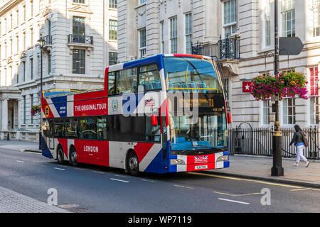 Einem oben offenen Sightseeing Bus in London wartet auf einige Passagiere Stockfoto