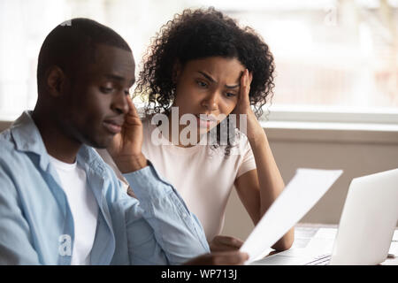 Frustriert biracial Paare fühlen sich mit finanziellen Problemen enttäuscht Stockfoto
