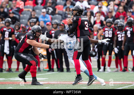 Ottawa, Kanada. 07 Sep, 2019. Ottawa Redblacks quarterback Jonathon Jennings (3) Sätzen während der CFL-Spiel zwischen den Toronto Argonauts und Ottawa Redblacks bei TD Place Stadion in Ottawa, Kanada mit einem entgegenkommenden Rush von Toronto Argonauten defensive lineman Robbie Smith (39) übergeben. Daniel Lea/CSM/Alamy leben Nachrichten Stockfoto