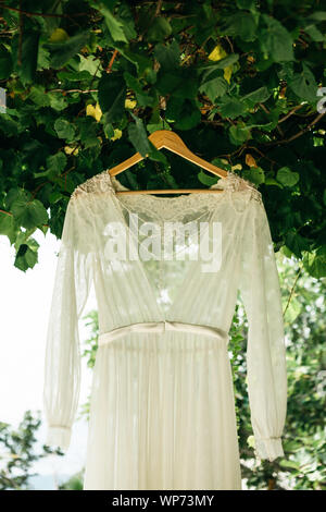 Hochzeit Kleid hängt auf einem Kleiderbügel outdoor. Vorbereitung auf die Hochzeit. Stockfoto