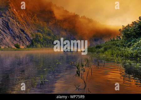 Sunrise malt die Morgennebel über dem Fluss in hellen und gesättigten orange-gelben Farben. Die braune und rosa Farben der Nebel absteigend zum Riv Stockfoto