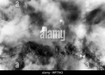 Kontrastreiche schwarz-wite von Oben nach Unten Blick auf die abgelegene Farm in Kangaroo Valley von Australien von dichten, weißen Nebel bedeckt. Stockfoto