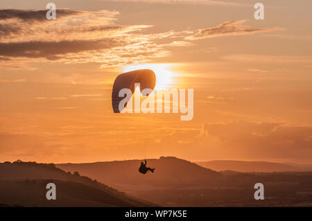 Devils Dyke, Brighton, Sussex, Großbritannien..7. September 2019. Gleitschirmflieger fliegen auf dem Nordwind über die schönen South Downs, während sich Nebel bewegt. . Stockfoto