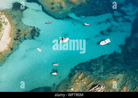 Ansicht von oben, atemberaubenden Blick auf einige Boote und Luxusyachten schwimmend auf einem türkisfarbenen Wasser. Maddalena Archipelago National Park, Sardinien. Stockfoto