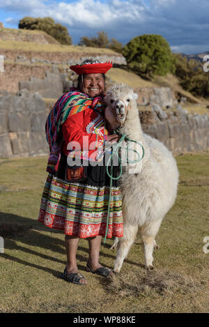 Cuzco, Peru - 14. Juli 2018. Peruanische Frau in traditionelle bunte Kleidung mit Alpaka/Lama in Sacsayhuaman, Cusco, Peru, Südamerika. Stockfoto