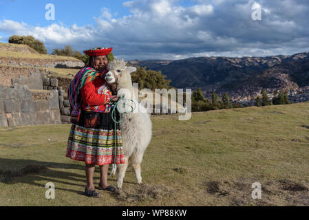 Cuzco, Peru - 14. Juli 2018. Peruanische Frau in traditionelle bunte Kleidung mit Alpaka/Lama in Sacsayhuaman, Cusco, Peru, Südamerika. Stockfoto