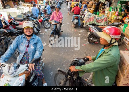 Ho Chi Minh City, Vietnam - April 15, 2019: Menschen auf Motorräder in einer Gasse am Cho Binh Tay Markt in Cho Lon (cholon). Stockfoto