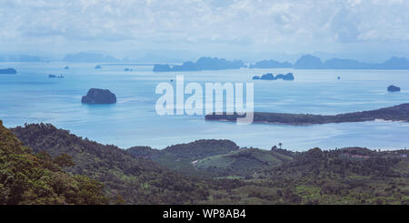 Schönen tropischen Panorama der hügelige Küste und glatte Meer Raum mit zahlreichen felsigen Inseln und Inselchen unter der Curly Himmel. Krabi, Thailand Stockfoto