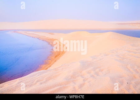 Wüste bei Sonnenaufgang, goldenen Farbton, bevor die Sonne über Sealine Dünen der Wüste und Binnensee mit seinen langen geschwungenen Strand. Stockfoto