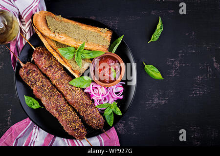 Kebap Adana, Lamm- und Rindfleisch und Toast mit Pesto. Ansicht von oben Stockfoto
