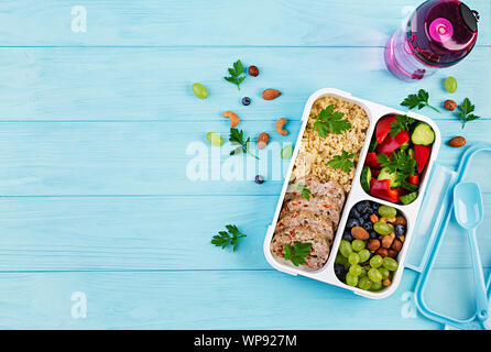 Lunch Box Hackbraten, Bulgur, Muttern, Gurke und Berry. Gesunde fitness Nahrung. Nehme. Brotdose. Ansicht von oben Stockfoto