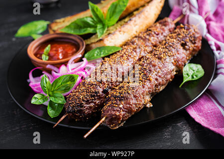 Kebap Adana, Lamm- und Rindfleisch und Toast mit Pesto. Stockfoto