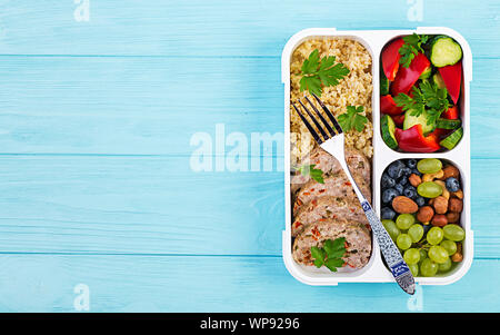 Lunch Box Hackbraten, Bulgur, Muttern, Gurke und Berry. Gesunde fitness Nahrung. Nehme. Brotdose. Ansicht von oben Stockfoto