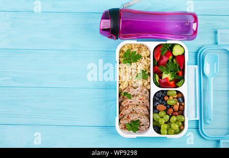 Lunch Box Hackbraten, Bulgur, Muttern, Gurke und Berry. Gesunde fitness Nahrung. Nehme. Brotdose. Ansicht von oben Stockfoto