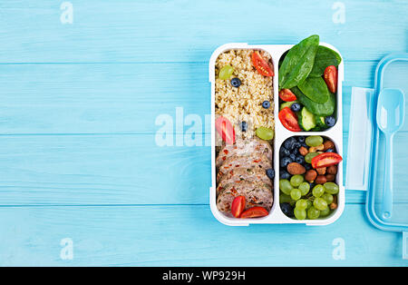 Lunch Box Hackbraten, Bulgur, Nüsse, Tomaten und Berry. Gesunde fitness Nahrung. Nehme. Brotdose. Ansicht von oben Stockfoto