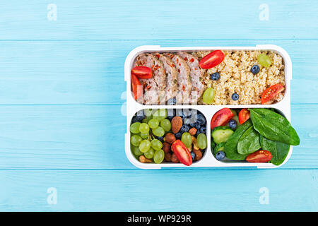 Lunch Box Hackbraten, Bulgur, Nüsse, Tomaten und Berry. Gesunde fitness Nahrung. Nehme. Brotdose. Ansicht von oben Stockfoto