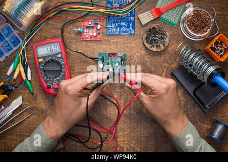 Hände Messen der Versorgungsspannung mit Prüfgerät. DIY, Elektronik, Reparatur, Konzept. Stockfoto