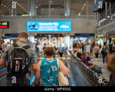 Mann und Frau stehen auf fahrsteig Flughafen Terminal Stockfoto